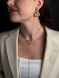 The "Horizon of Desire" pendant is beige and gold